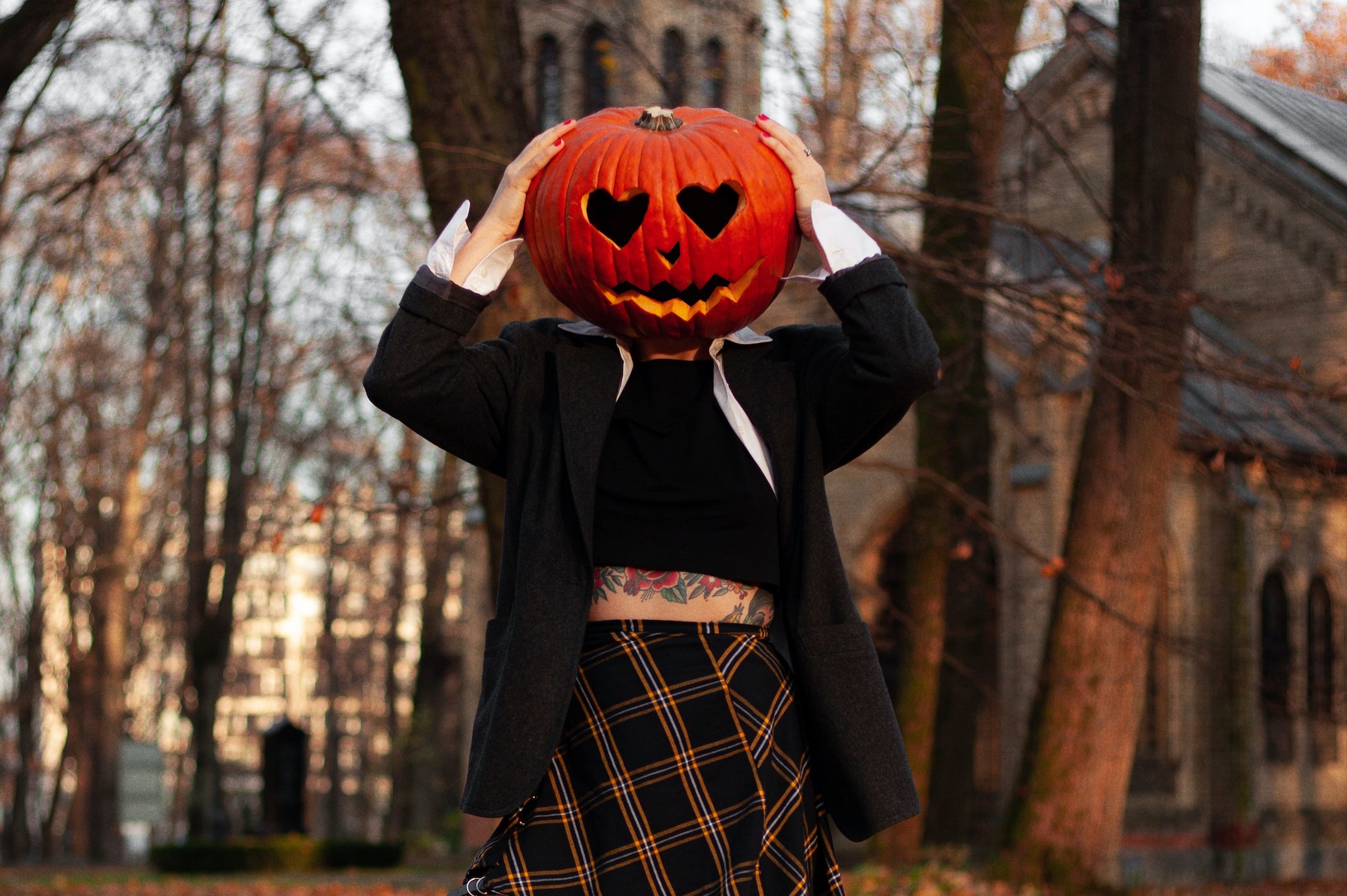 Frau in Halloween Kostüm mit Kürbis auf dem Kopf